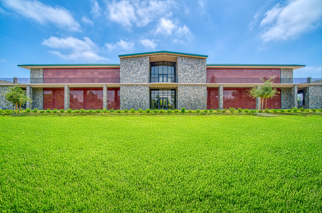 Exterior view of newly constructed mausoleum with polished stone façade Front entrance of mausoleum featuring engraved nameplate and custom doors Wide-angle shot of mausoleum structure under clear sky during final phase of construction